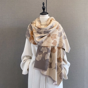 Winter beige pashmina scarf with ginkgo leaf pattern and fringe on female mannequin