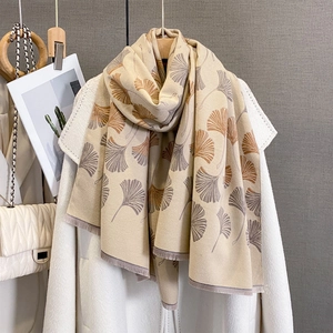 Detail of soft pashmina scarf with ginkgo leaf jacquard pattern and tassel edges