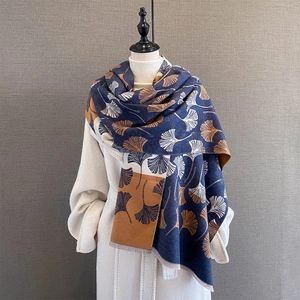 Detail of ginkgo leaf jacquard pattern on navy and caramel thick cashmere-like scarf
