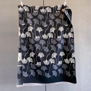 Detail of black cashmere-like scarf with silver ginkgo leaf pattern and fringe edges