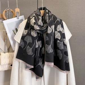 Vintage ginkgo leaf jacquard scarf with fringe trim worn over a white winter coat