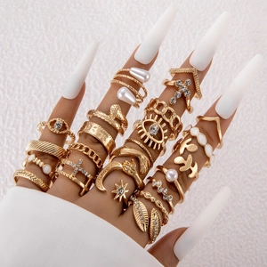 Detail of bohemian gold stackable rings set with pearls and rhinestones on hands