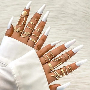 Close-up of gold stacking rings set with butterfly and snake patterns on faux fur