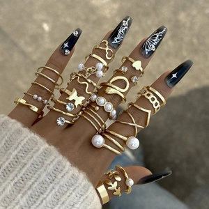 Golden stackable ring set with pearls and butterfly accents on model hand