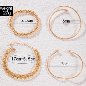 Detailed view of four-piece gold chain bracelet set with various link styles and sizes