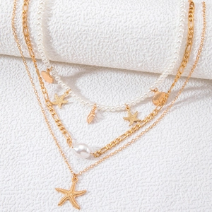 Three-layer gold starfish shell necklace with white pearls for a vintage beach look