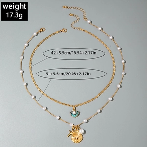 Detail of layered starfish and shell necklaces with pearls and gold chain links