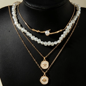 Close-up of layered bohemian necklace set with starfish shells and faux pearls