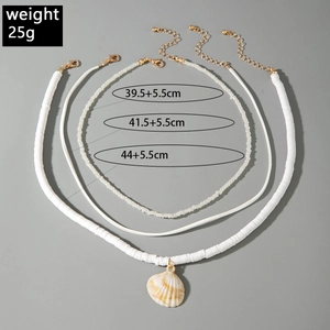 Detailed view of triple-layered beaded necklace with natural shell pendant and gold clasp