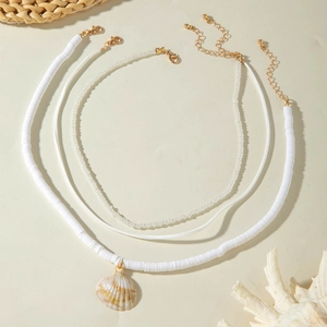 Close-up of triple-layered ocean necklace with heishi beads and natural shell pendant