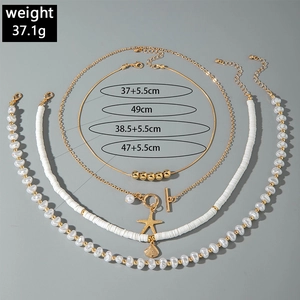 Detail of layered gold beaded necklaces featuring starfish and seashell beach pendants