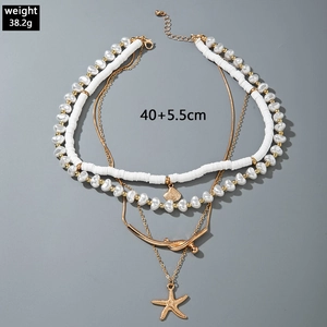 Detail of multi-layer beaded necklace with starfish, seashell pendants and pearls