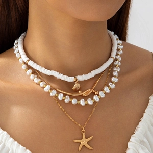 Detail of layered ocean-themed necklace with starfish, shell charms and baroque pearls
