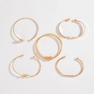 5-piece gold bangle set with geometric knots and open cuffs on white background