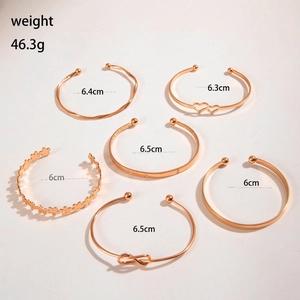 Detail showing set of 6 rose gold open bangles with floral and heart patterns