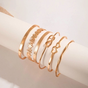 Detail of 6-piece gold bangle set with LOVE engraving and twisted pattern
