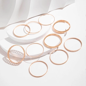 Close-up of a 10-piece gold bracelet set with twisted, smooth, and chain textures