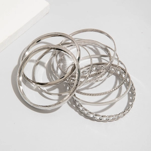 Macro shot of silver-plated stackable bracelets featuring varied textures and chain designs