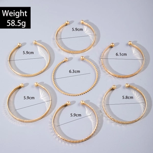 Macro view of 7-piece gold bangle set showing twisted textures and bead details