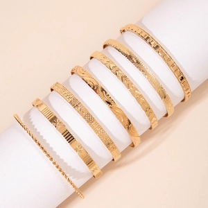 Detailed view of 8-piece gold textured bangles featuring embossed patterns and twisted design