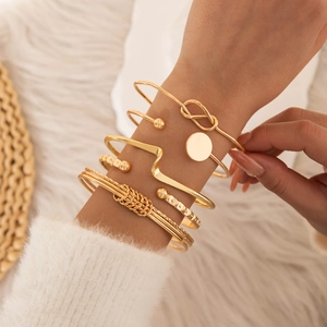 Detail of six-piece luxury gold plated bracelet set styled on model with diverse patterns