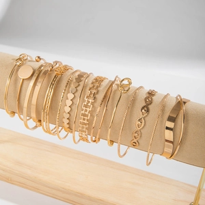 Detail of 12-piece gold bracelet set showing various textures and patterns on display