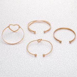 Detail of four-piece gold open bracelet set featuring heart and twisted textured designs