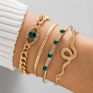 Four-piece gold bracelet set with emerald green stones and snake devil eye charms