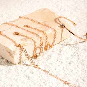 Detail von roségoldenem Schmuckset mit Sterndiamanten und Anhängern auf Stein