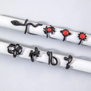 Macro view of gothic black ring set featuring spider, snake, skull and red gemstone details