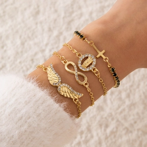 Dettaglio del set di quattro bracciali dorati con ali d'angelo, simbolo infinito e croci