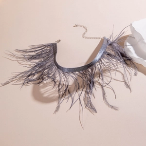 Détail du ras-de-cou en plumes grises avec chaîne en métal argenté et fermoir mousqueton