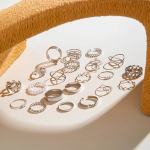 Nahaufnahme des 18-teiligen silbernen Ring-Sets mit Kunstperlen und Blumenmustern