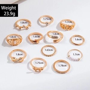 Detaillierte Flachbildansicht von 11 goldfarbenen Ringen mit Schmetterlings- und Perlendesign