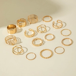 Makro-Detail eines 15-teiligen goldenen Ring-Sets mit verschiedenen geometrischen Texturen