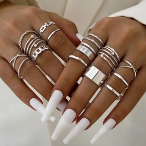 Details eines silbernen Stapelring-Sets mit gedrehten Designs an einer Hand gezeigt