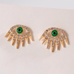 Detail view of gold-tone eye earrings with green enamel pupils and sparkling rhinestones