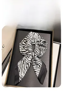 Vue détaillée d'un foulard en soie à motif zébré noir et blanc sur un plateau de luxe