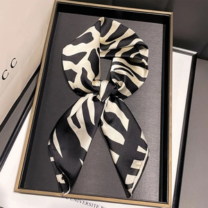 Élégant foulard en soie à imprimé zèbre noué en nœud sur un plateau décoratif