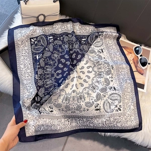 Detailed close-up of blue paisley silk scarf texture on a soft white fur background