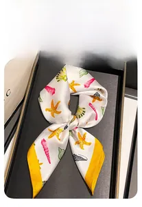 Gros plan d'un foulard en soie avec imprimé coquillages dans un coffret cadeau