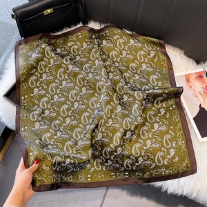Detail of olive green paisley silk scarf featuring contrasting dark brown stitched edges