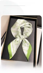 Détail d'un foulard en soie avec motifs de coquillages et bordure verte