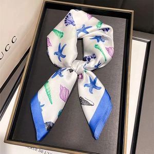 Détail macro d'un foulard en soie avec imprimés marins d'étoiles de mer et coquillages