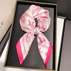 Détail d'un foulard en soie avec coquillages roses et étoiles de mer noué en boucle