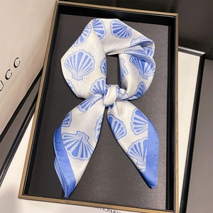 Vue détaillée du foulard en soie avec imprimé coquillage bleu et bordure élégante