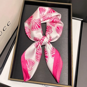 Détail d'un foulard élégant avec motifs de coquillages roses sur un plateau noir