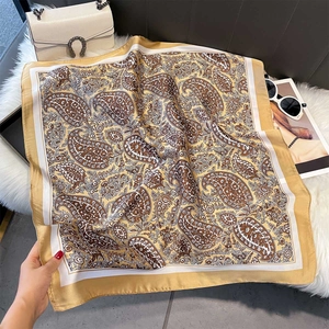 Detail of vintage paisley print silk scarf in yellow and brown with luxury draping