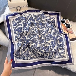 Detailed macro view of retro paisley print silk scarf on a soft luxury textured background