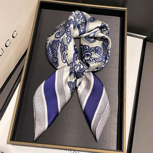 Close-up of silk scarf with paisley patterns in a black tray for elegant neck styling